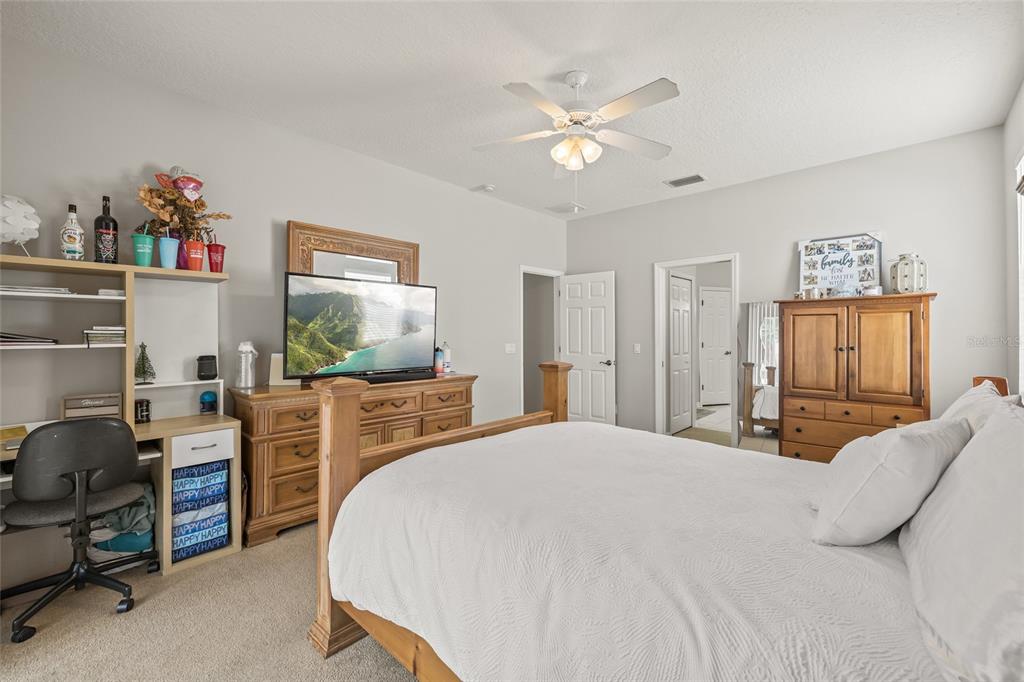 144 Costa Loop Auburndale, FL 33823 - Photo 16 of 34 a bedroom with a bed and a chandelier