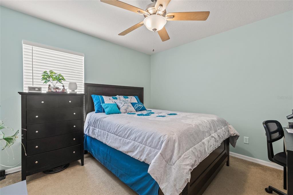 144 Costa Loop Auburndale, FL 33823 - Photo 20 of 34 a bedroom with a bed and a chandelier