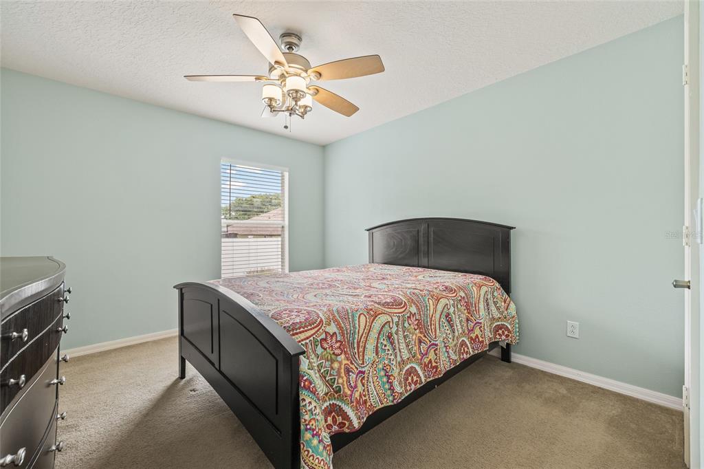 144 Costa Loop Auburndale, FL 33823 - Photo 25 of 34 a bedroom with a bed and a chandelier
