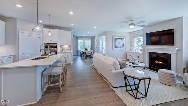 a kitchen with stainless steel appliances granite countertop a sink a stove a refrigerator and island with wooden floor