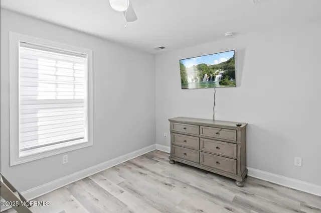a view of room with window and wooden floor