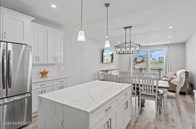 a kitchen with stainless steel appliances a stove a sink a refrigerator a center island and cabinets