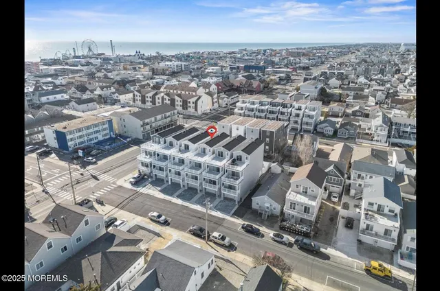 an aerial view of a residential apartment building in front of a yard