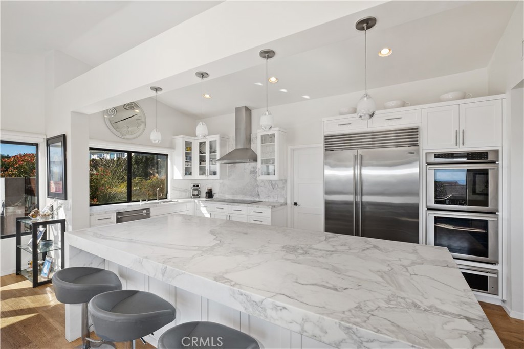 32182 Sea Island Drive Dana Point, CA 92629 - Photo 19 of 48 a kitchen with stainless steel appliances kitchen island granite countertop a sink refrigerator and cabinets