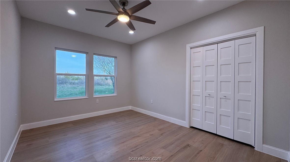 3917 Harbor Bolton Road Franklin, TX 77856 - Photo 13 of 26 an empty room with wooden floor closet and windows fan