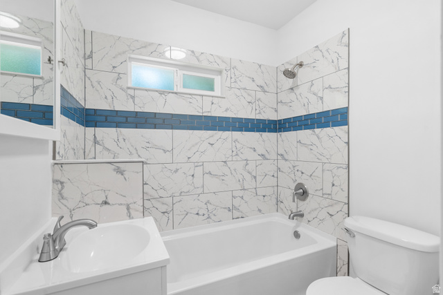 2862 Fowler Avenue Ogden, UT 84403 - Photo 14 of 23 Full bathroom featuring a white bathtub and shower with marble-look wall tiles, accented by a blue subway tile band