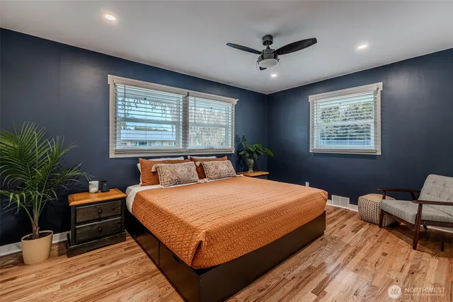 a bedroom with a large bed a chandelier and a window