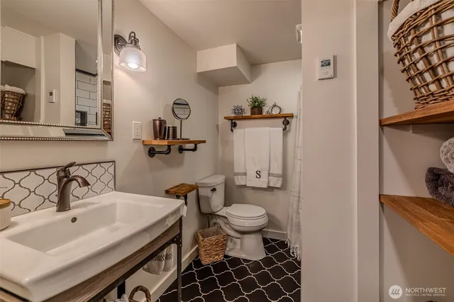 a bathroom with a sink toilet and a mirror