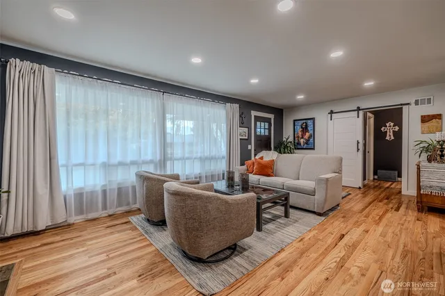 a living room with furniture and a wooden floor