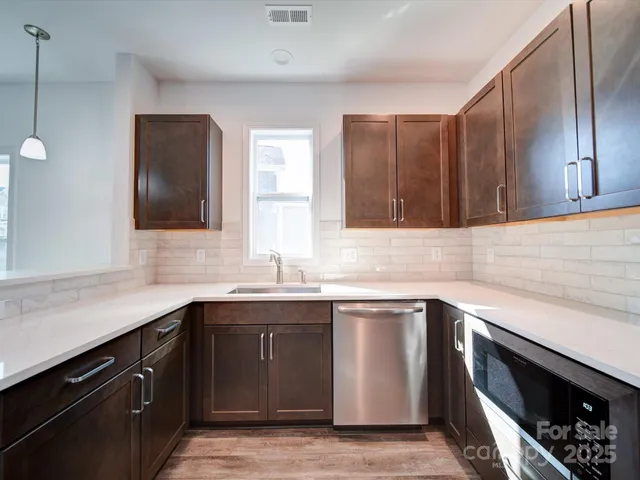 a kitchen with a sink a window and stainless steel appliances
