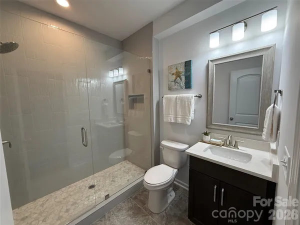 a bathroom with a sink a toilet a shower and a mirror