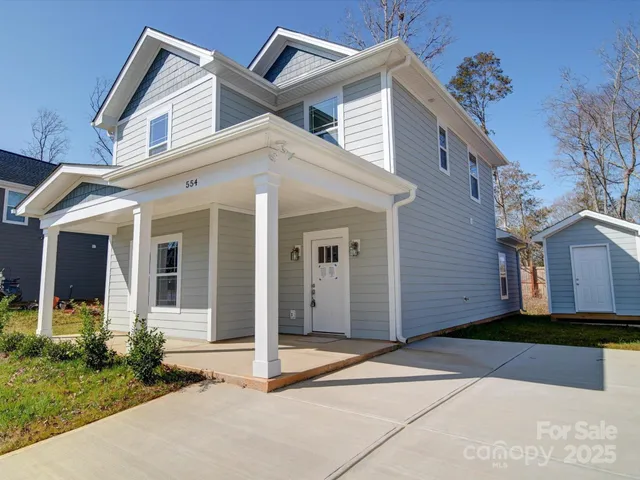a front view of a house with a yard and potted plants
