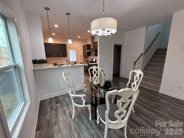 a view of a dining room with furniture a chandelier and wooden floor