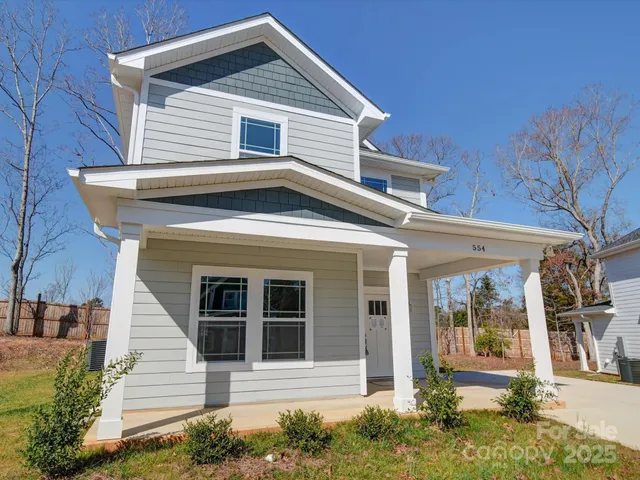 an empty room with wooden floor a ceiling fan and windows