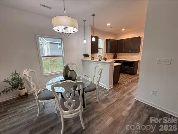 a view of a dining room with furniture a chandelier and wooden floor