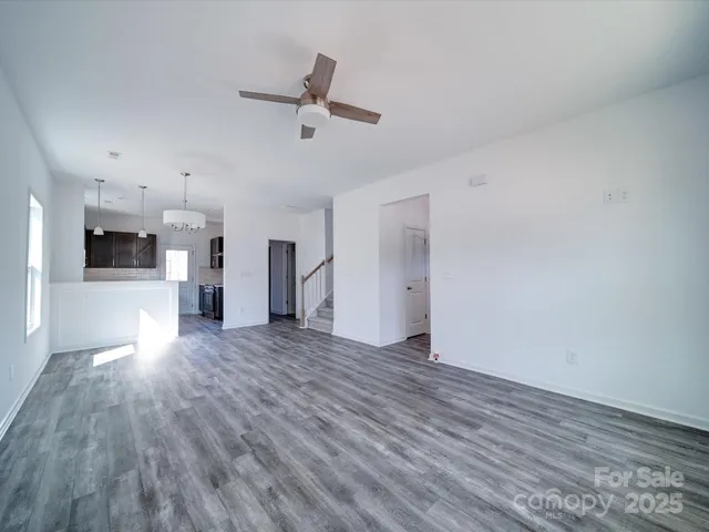 a view of a hallway with wooden floor and a chandelier