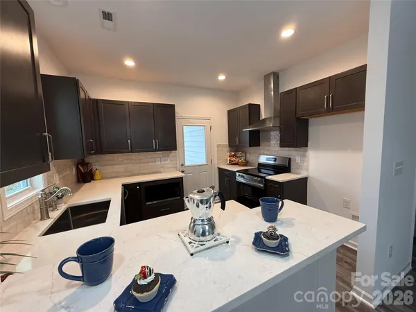 a kitchen with granite countertop a sink appliances and cabinets