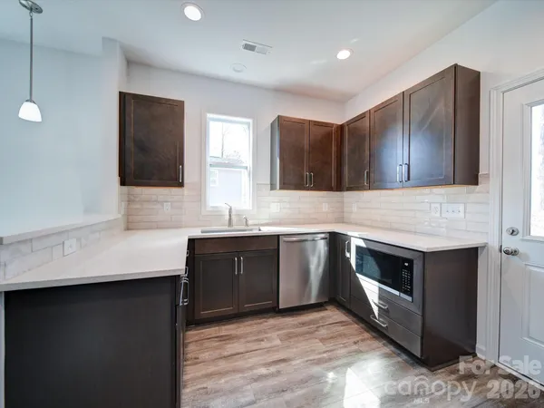 a kitchen with stainless steel appliances granite countertop a sink stove and microwave