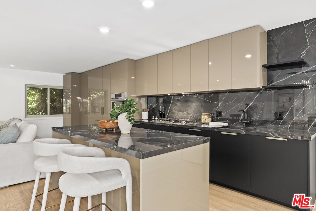 a kitchen with stainless steel appliances granite countertop a sink and a stove