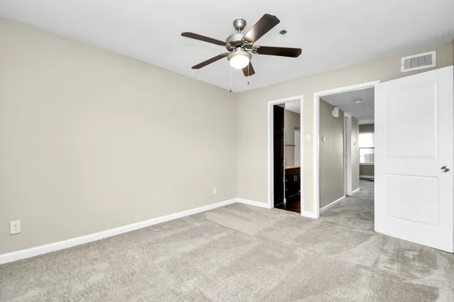 an empty room with a ceiling fan and a window