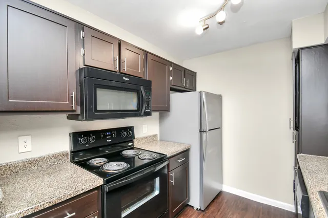 a kitchen with stainless steel appliances granite countertop a sink stove and cabinets