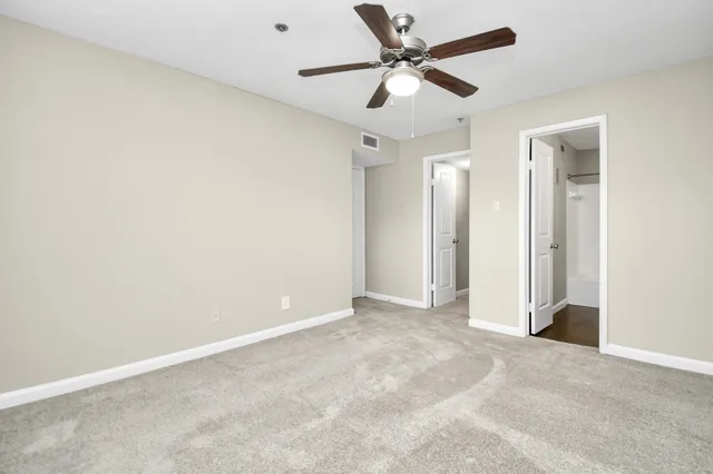 an empty room with a window and a fan