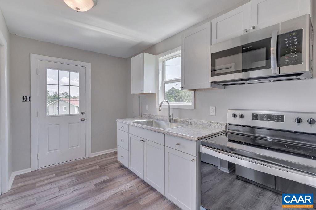 8087 Chestnut Grove Road Esmont, VA 22937 - Photo 18 of 36 a kitchen with stainless steel appliances a stove microwave and cabinets