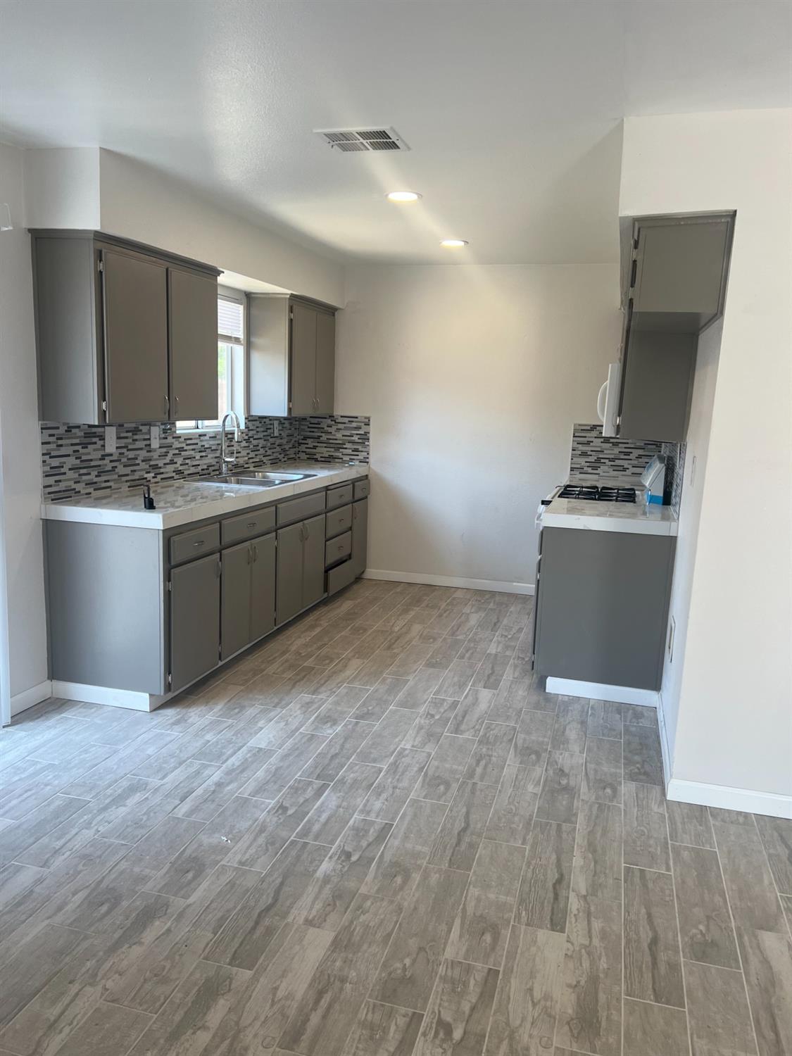 328 Hull Avenue Madera, CA 93638 - Photo 5 of 10 a kitchen with stainless steel appliances granite countertop a sink and a stove