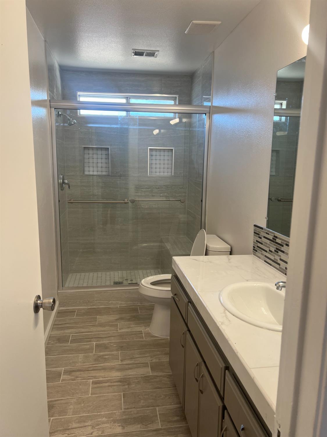 328 Hull Avenue Madera, CA 93638 - Photo 6 of 10 a bathroom with a sink a mirror and a shower