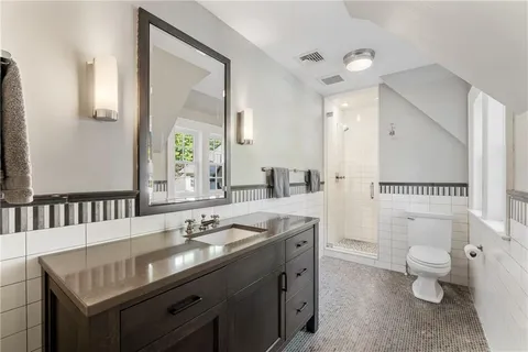 a spacious bathroom with a toilet a sink and a mirror