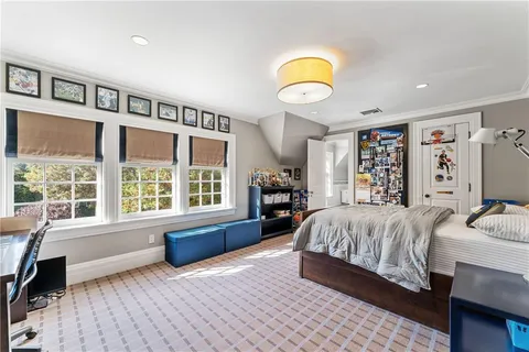 a bedroom with a bed and a large window