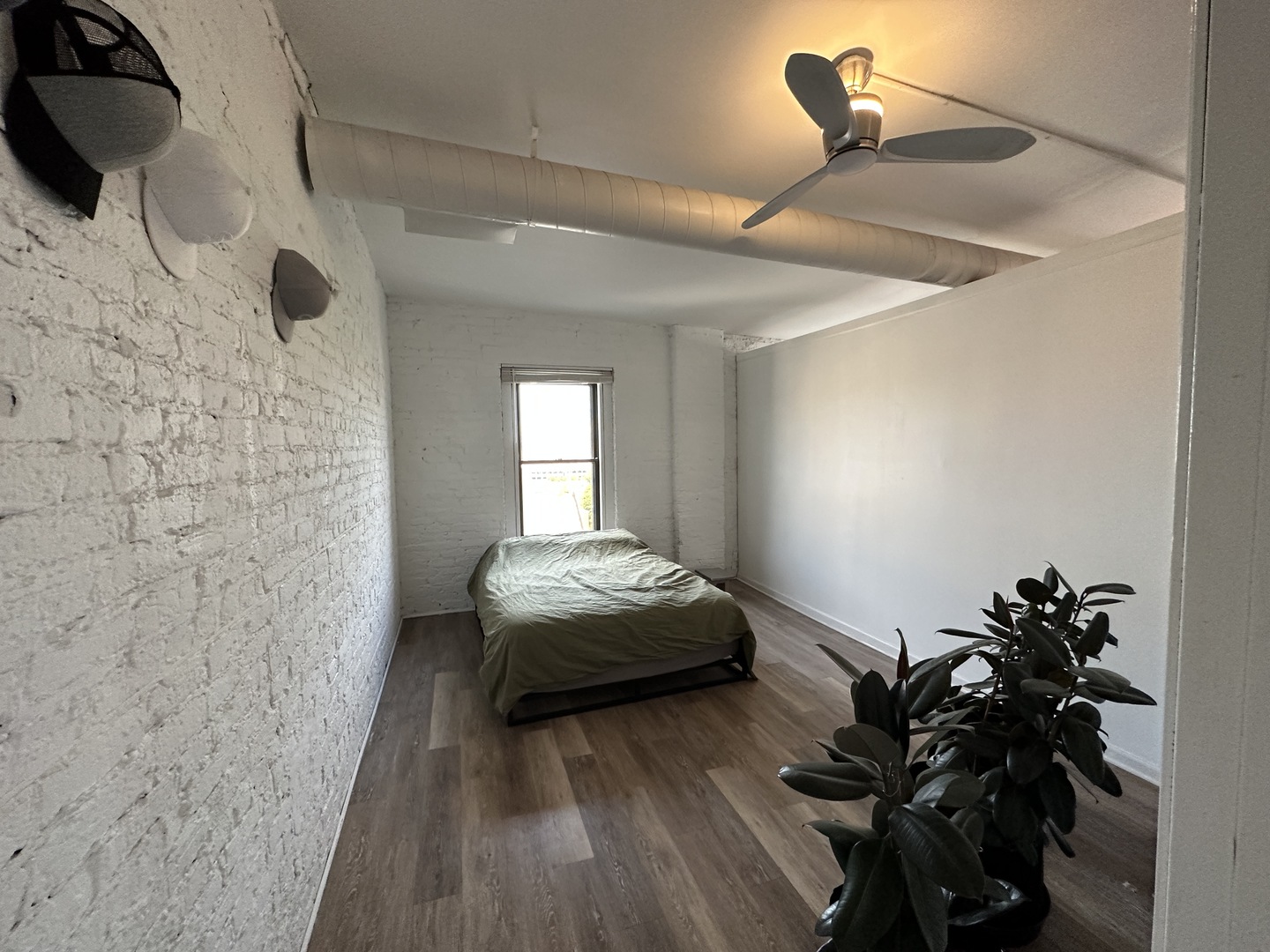 1237 North Noble Street, Unit 4 Chicago, IL 60642 - Photo 16 of 27 a bedroom with a bed and a potted plant