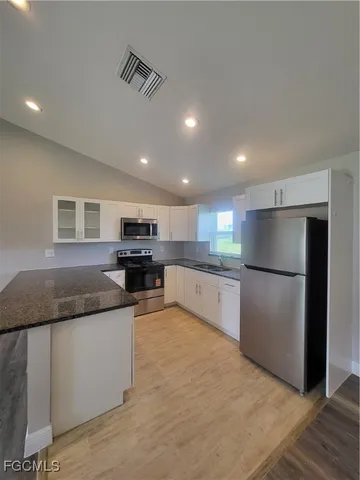 a kitchen with stainless steel appliances granite countertop a refrigerator a sink and a stove