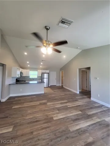 a view of an empty room and kitchen view