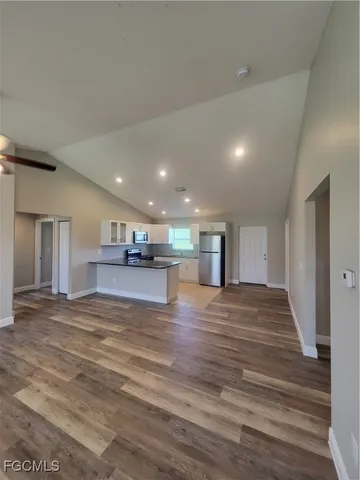 a view of empty room with kitchen and window