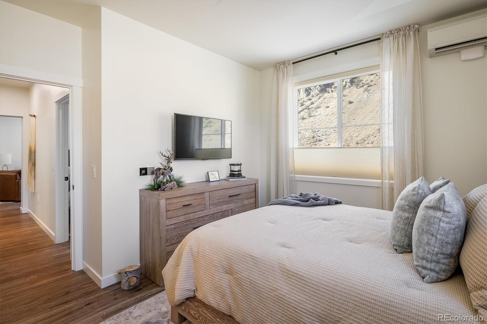 2121 Hummingbird Way, Unit 201 Georgetown, CO 80444 - Photo 9 of 29 a bedroom with a bed and a flat tv screen on dresser