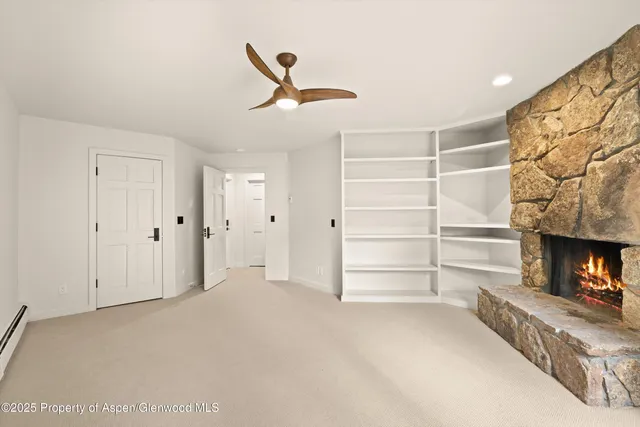 a view of a livingroom with a fireplace and a ceiling fan