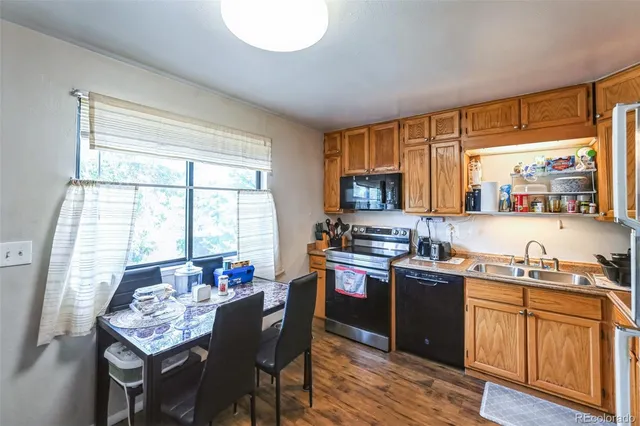 a kitchen with stainless steel appliances granite countertop sink stove top oven and cabinets