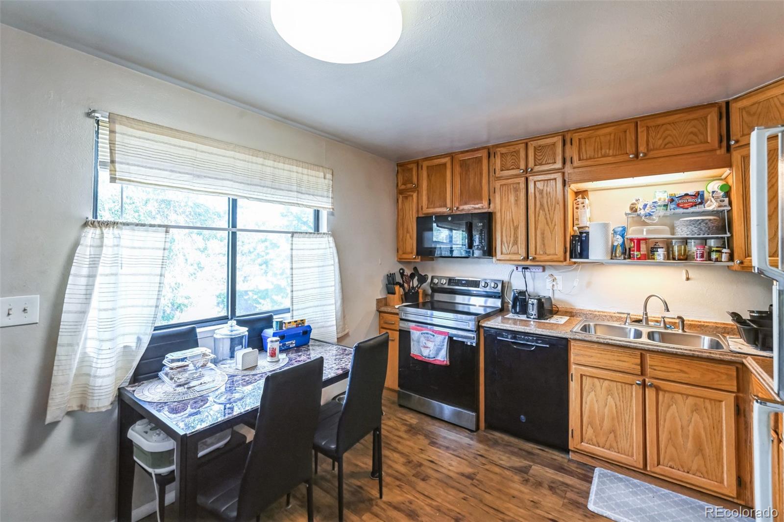 15640 East Eldorado Drive Aurora, CO 80013 - Photo 13 of 33 a kitchen with stainless steel appliances granite countertop sink stove top oven and cabinets