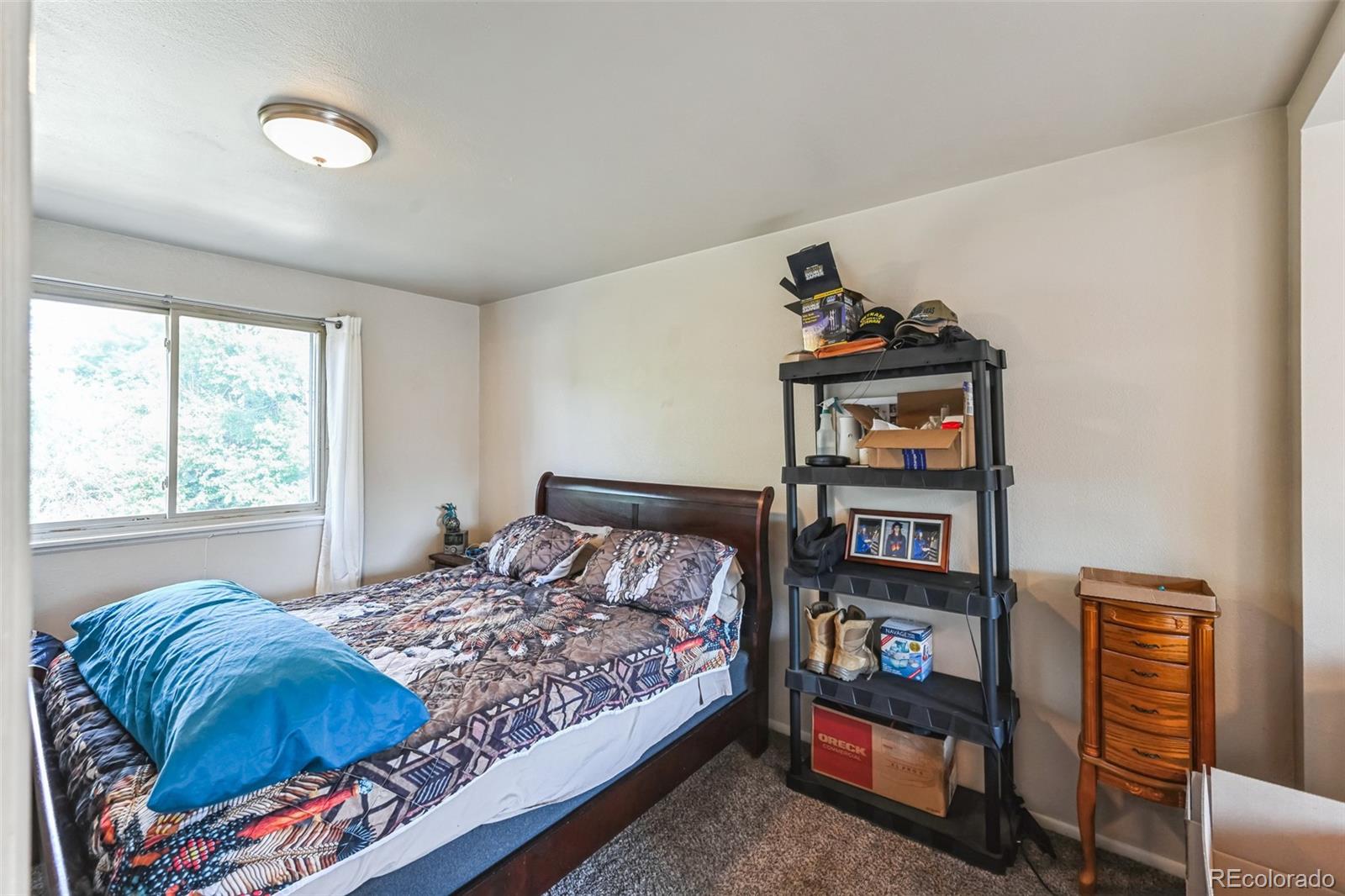 15640 East Eldorado Drive Aurora, CO 80013 - Photo 15 of 33 a bedroom with a bed and a book shelf