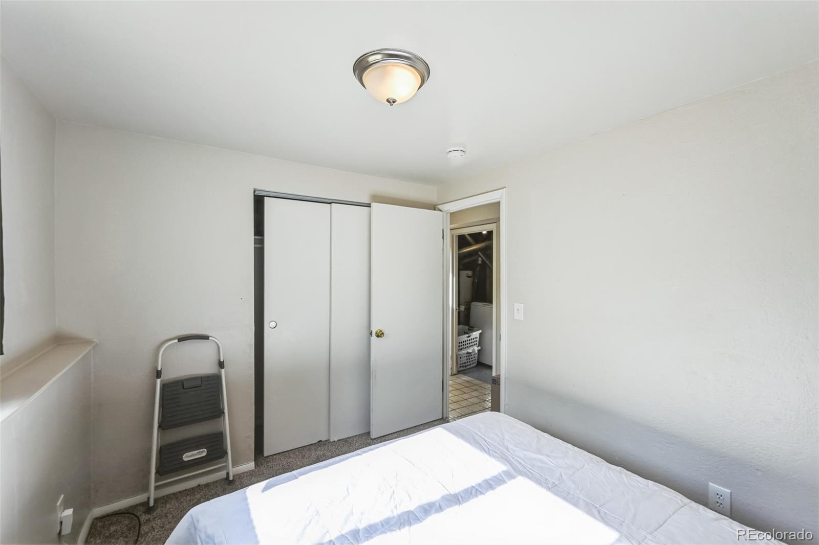 15640 East Eldorado Drive Aurora, CO 80013 - Photo 19 of 33 a bedroom with a bed and a mirror