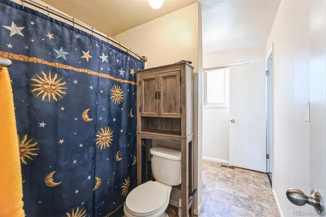 a bathroom with a toilet and a shower