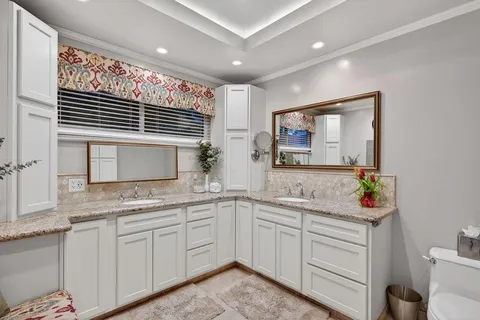 a bathroom with a granite countertop sink toilet and a mirror