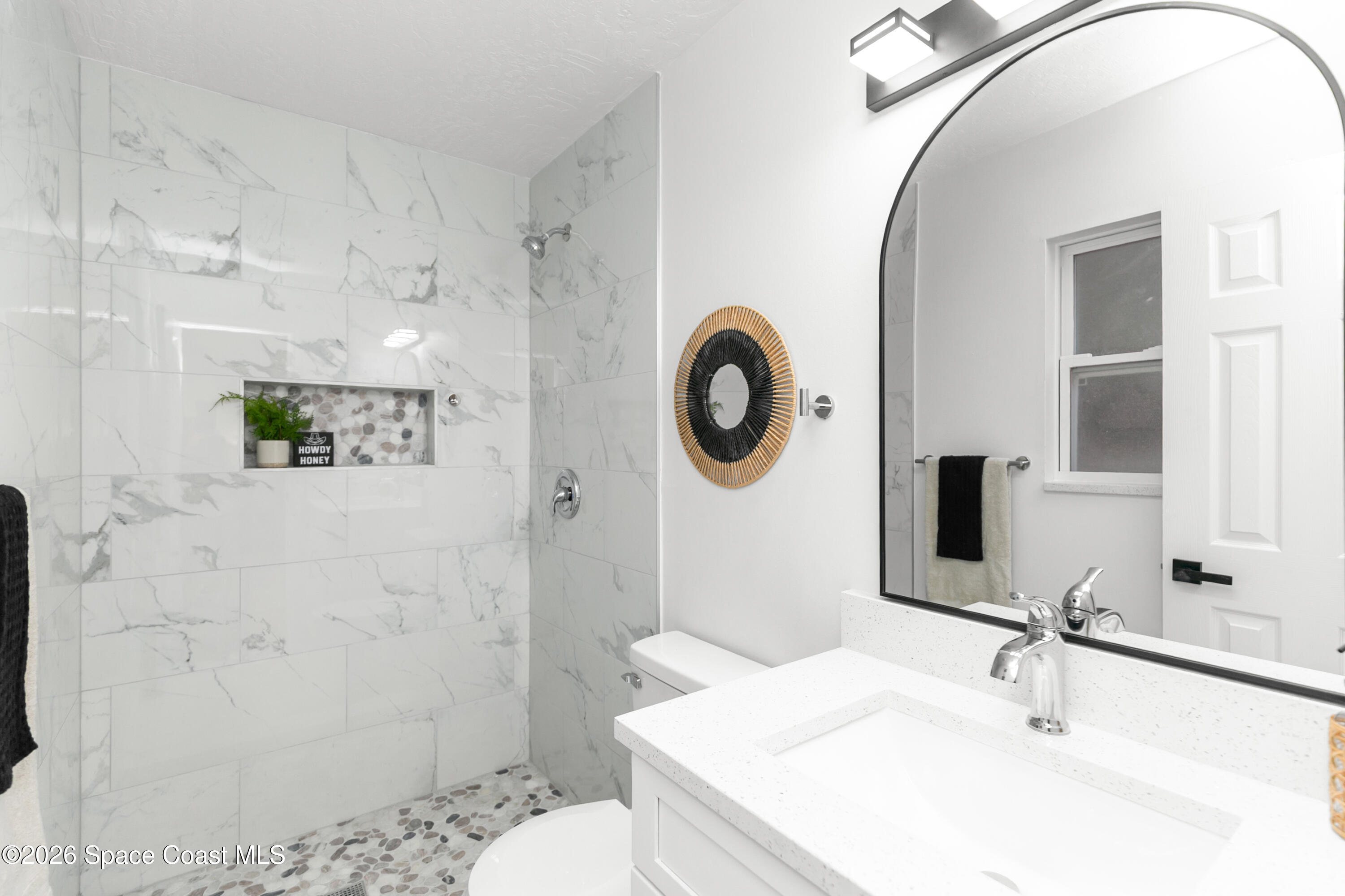 5095 Hogan Place Cocoa, FL 32927 - Photo 17 of 23 a bathroom with a sink a toilet and a mirror