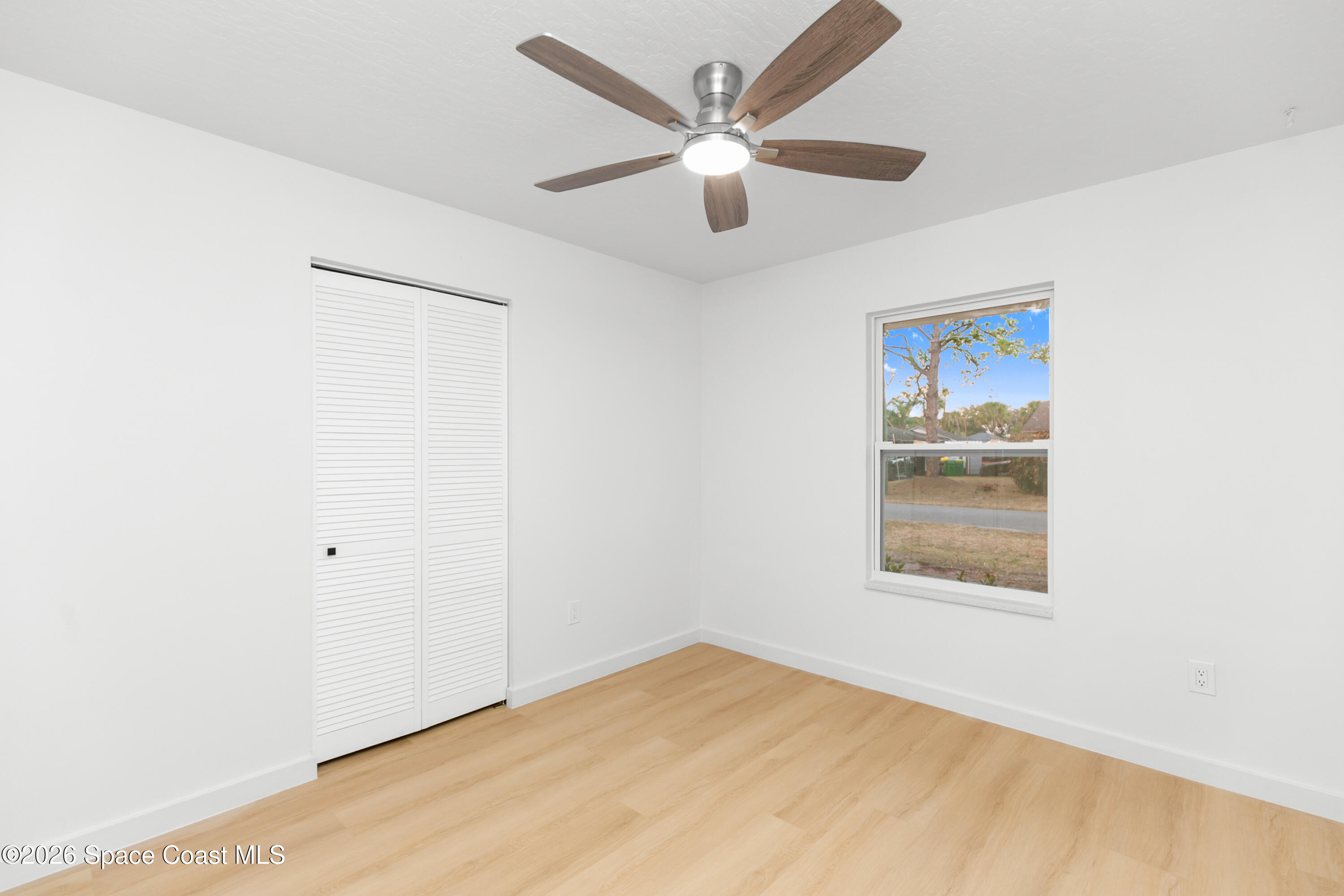 5095 Hogan Place Cocoa, FL 32927 - Photo 18 of 23 an empty room with a window and a ceiling fan