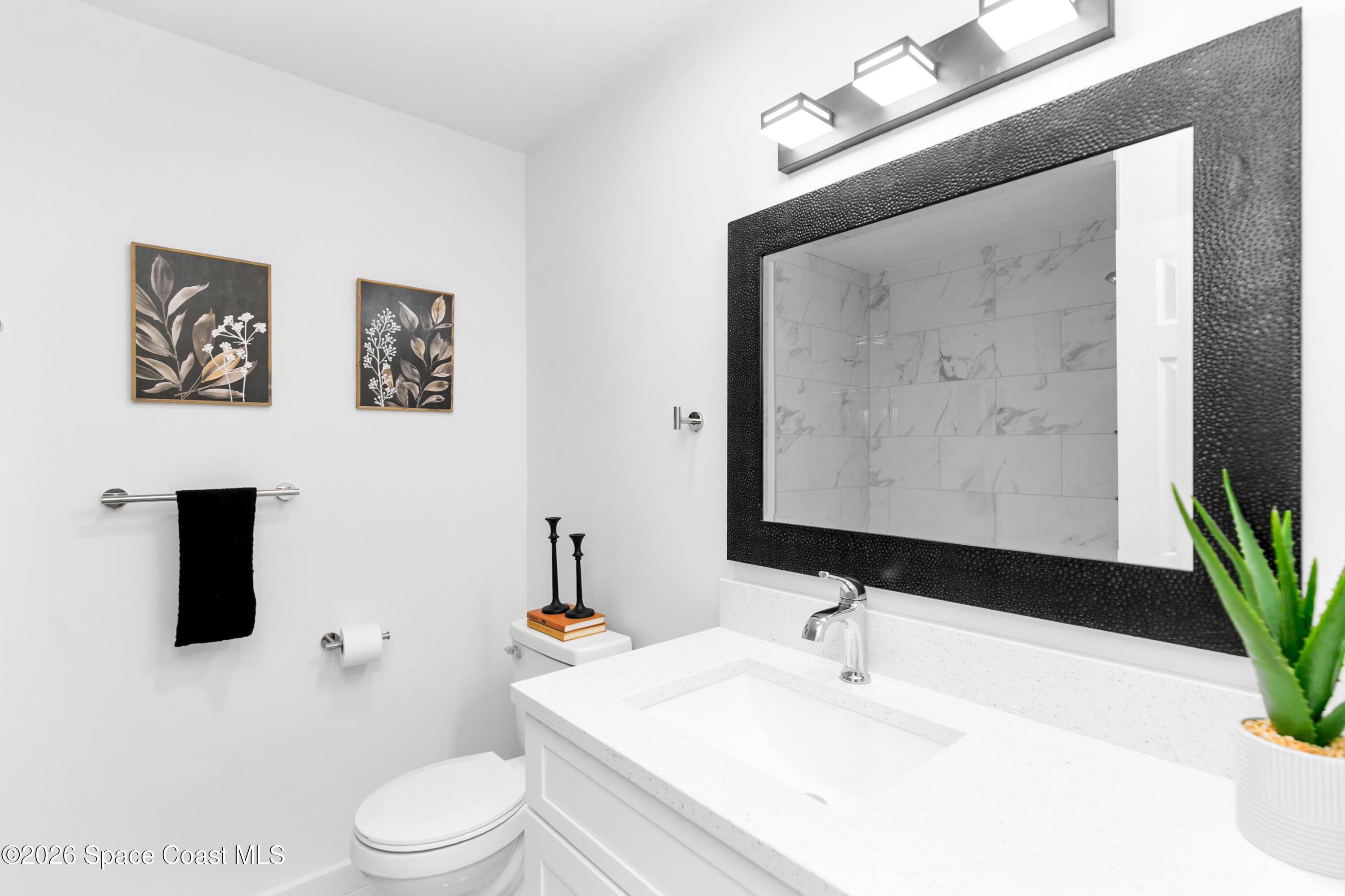 5095 Hogan Place Cocoa, FL 32927 - Photo 20 of 23 a bathroom with a toilet a sink and mirror