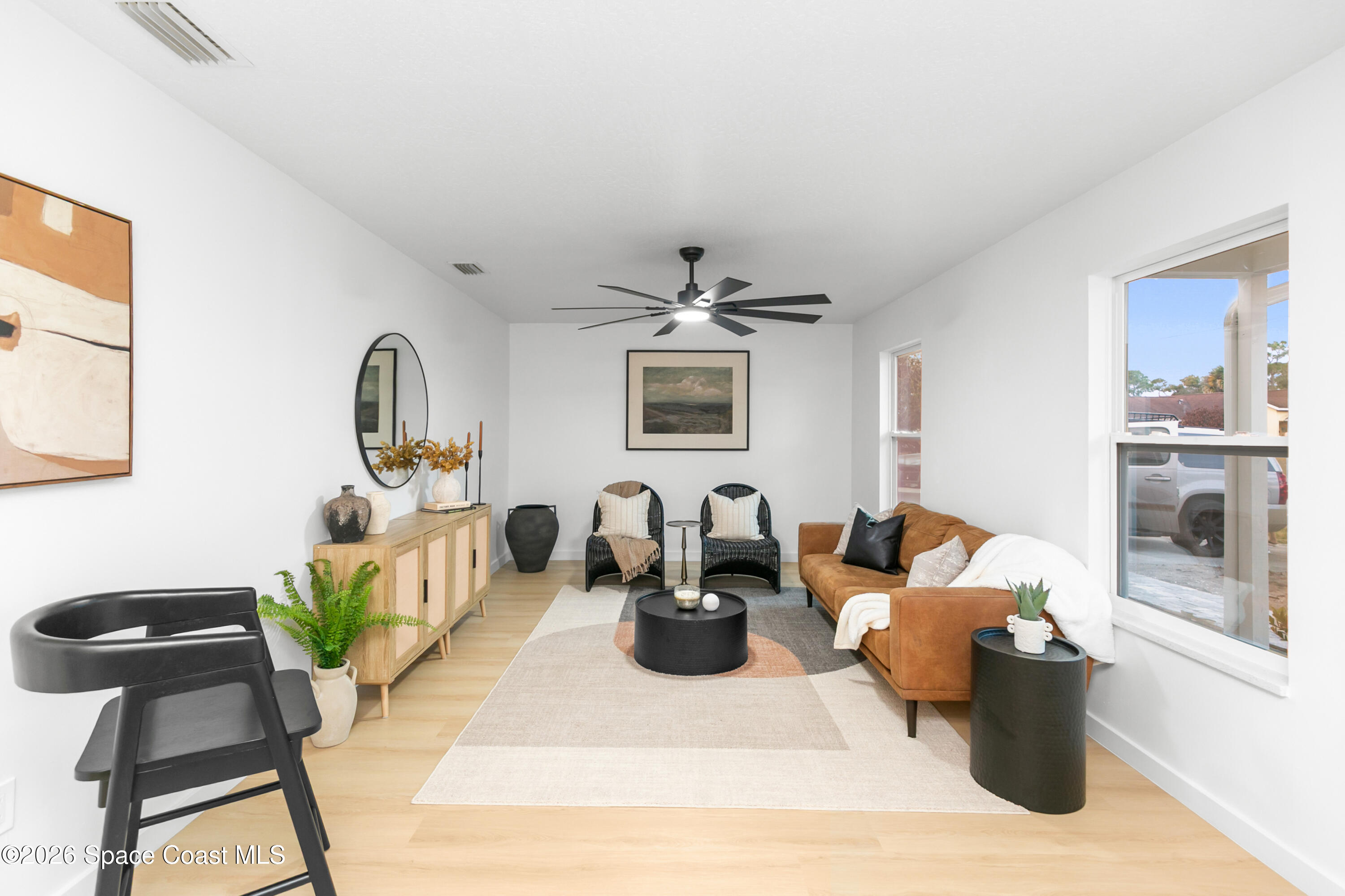 5095 Hogan Place Cocoa, FL 32927 - Photo 3 of 23 a living room with furniture a chandelier and a window