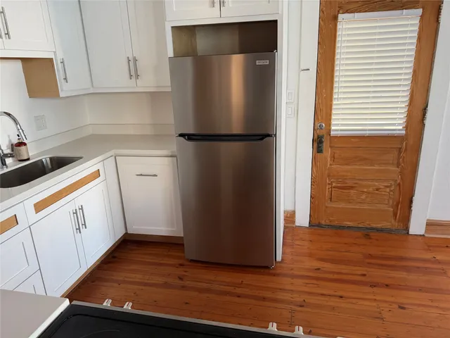 a kitchen with a refrigerator sink and cabinets