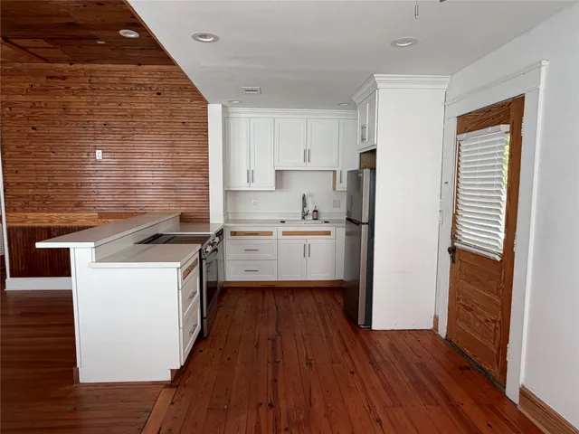 a kitchen with wooden floors and white appliances