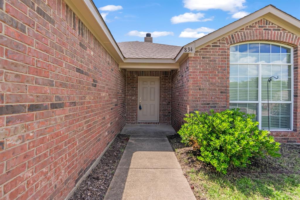 834 Hazel's Way Anna, TX 75409 - Photo 3 of 21 Brick exterior with a covered entry, concrete walkway, and an arched transom window